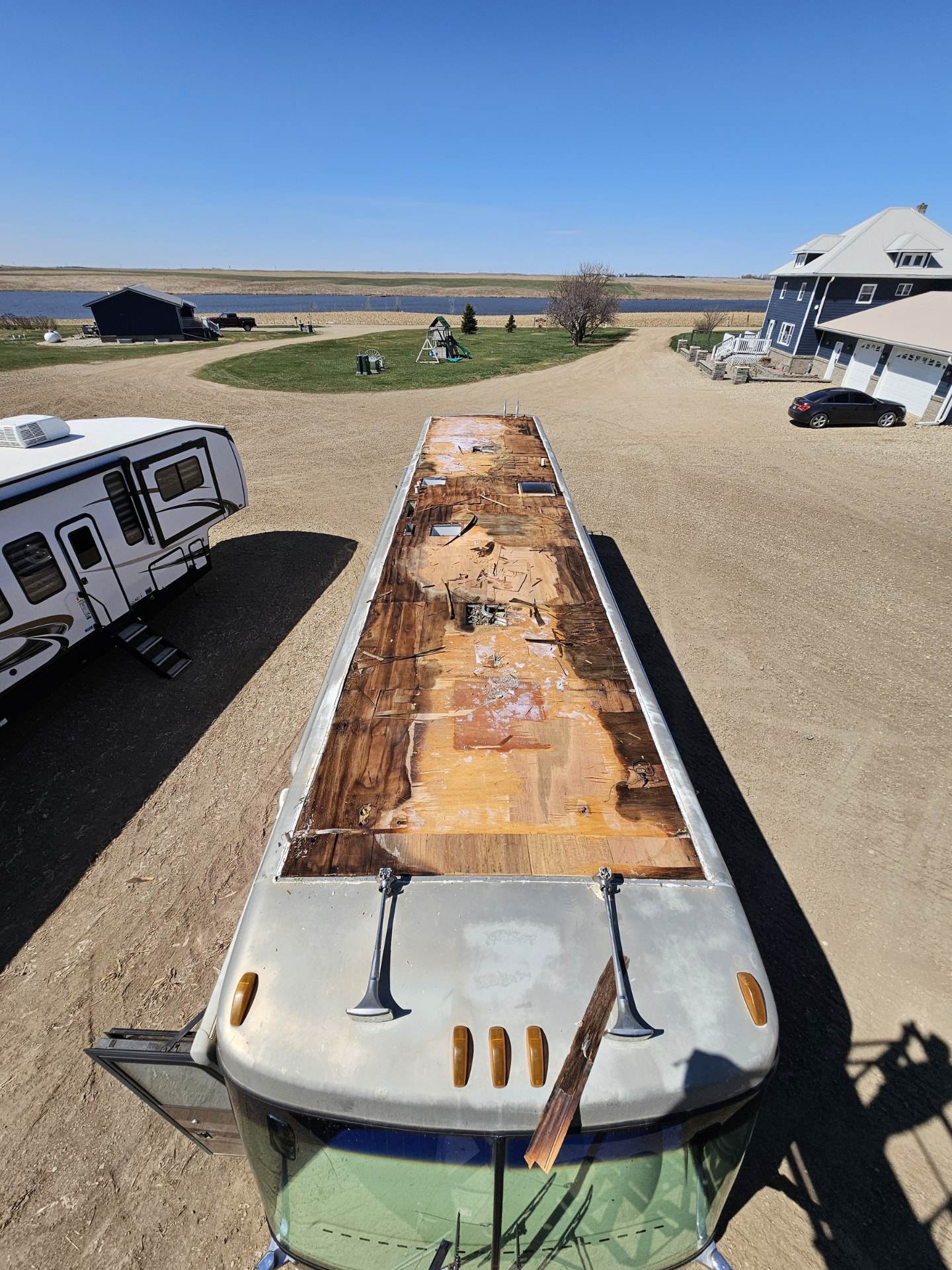 Camper roof opened for repair at a lakeside property